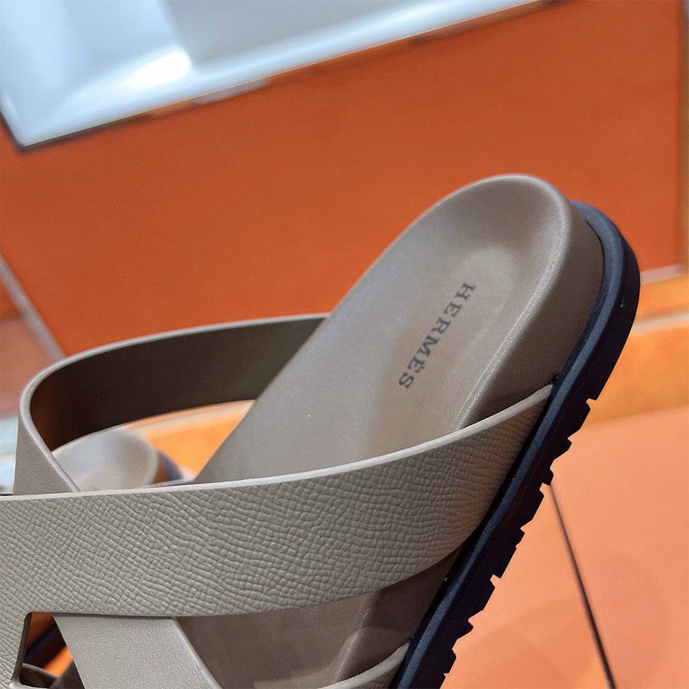 Kazimir Sandal by 24HEARTZ featuring a stylish open-toe design with ankle straps and a comfortable flat sole.